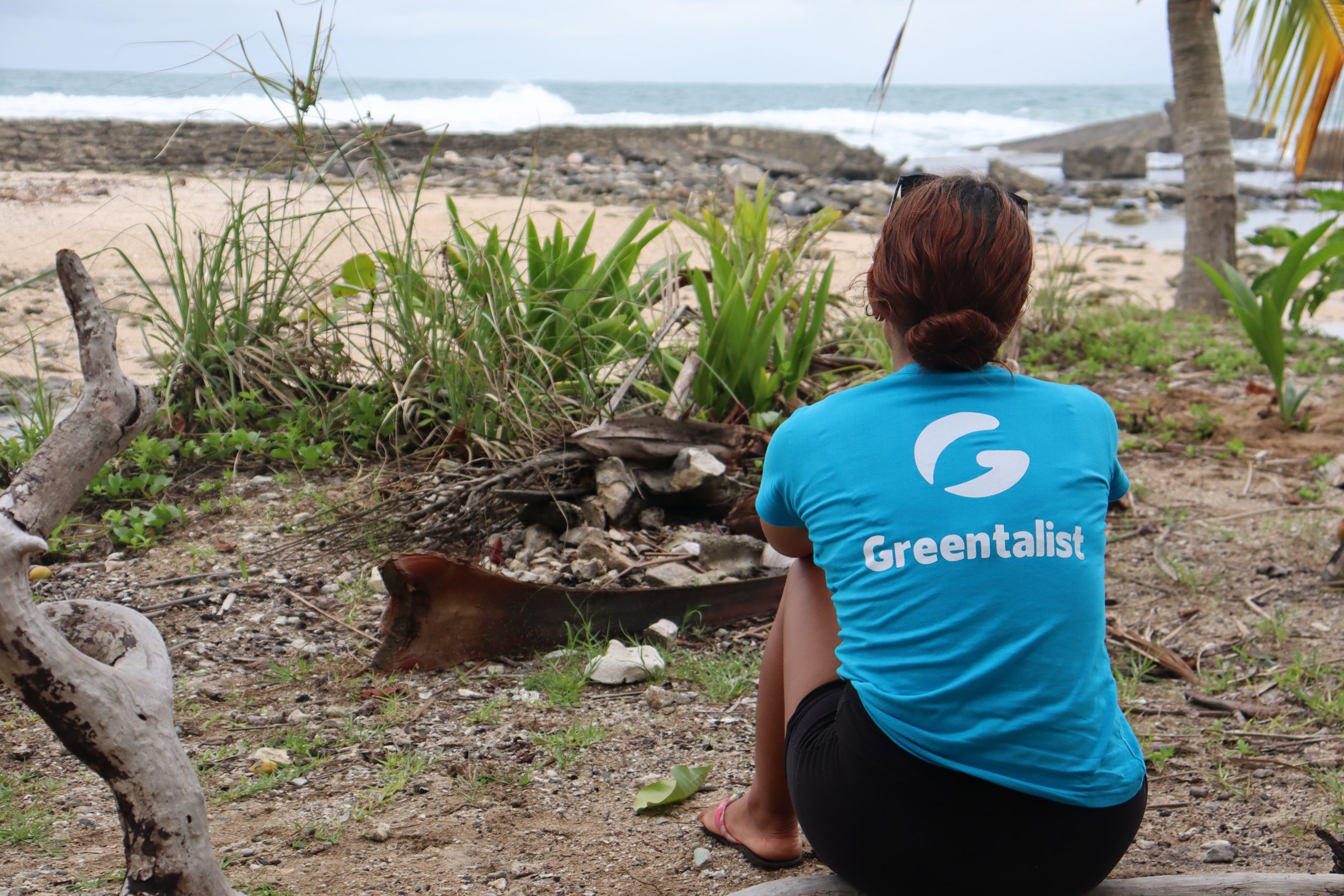 Persona voluntaria observando el océano durante una jornada ambiental.